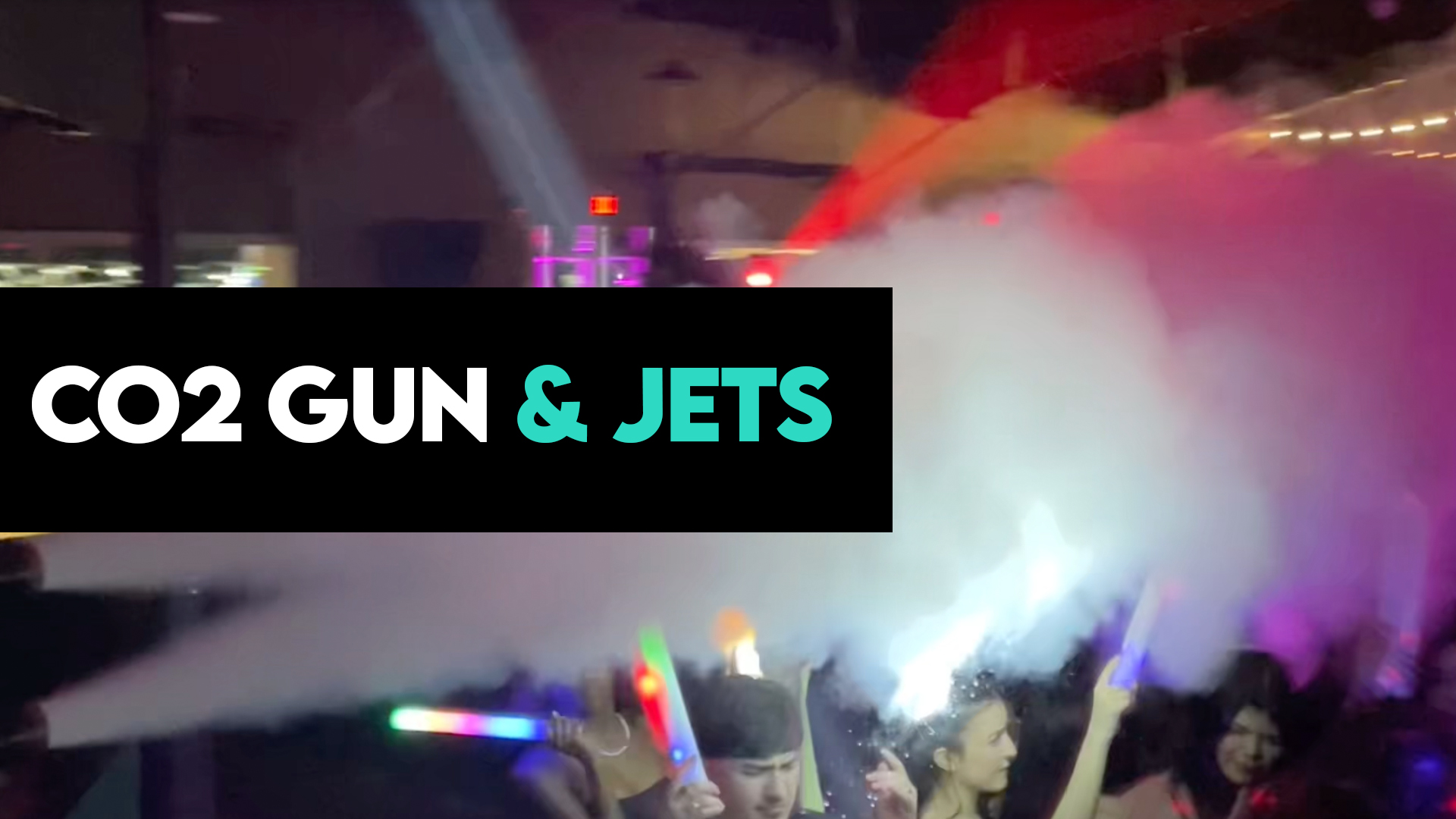 CO₂ blasters shooting powerful white plumes over a packed dance floor during a live event