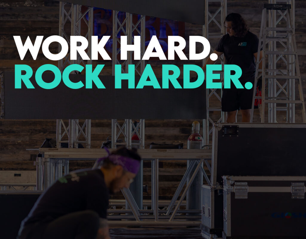 DJ and event production team setting up sound, lighting, and stage equipment for a live event